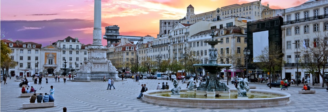 La place Rossio à Lisbonne, Portugal remplie de gens alors que le soleil commence à se coucher