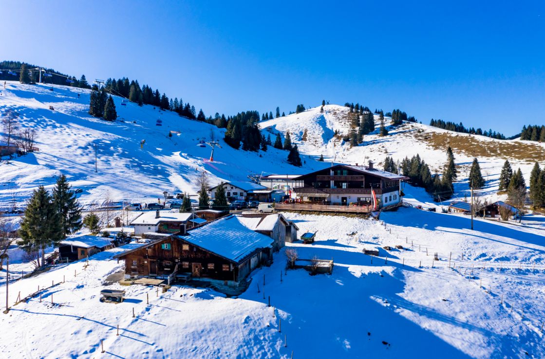 Sudelfeld im Schnee unter blauem Himmel.