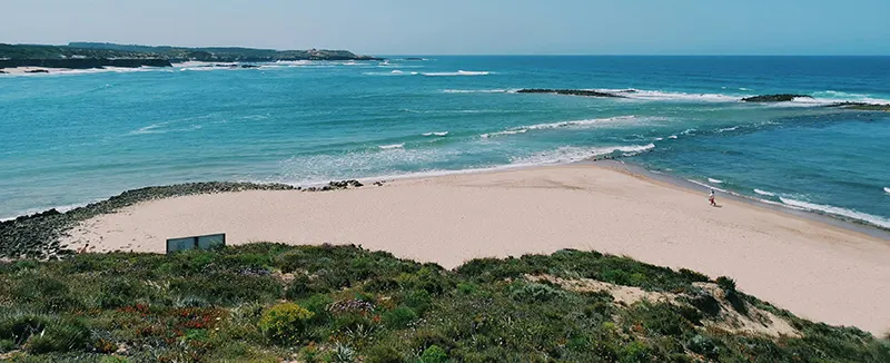 Mar azul y tranquilo bajo un cielo despejado durante el día, ideal para vacaciones de playa y descanso en la costa.
