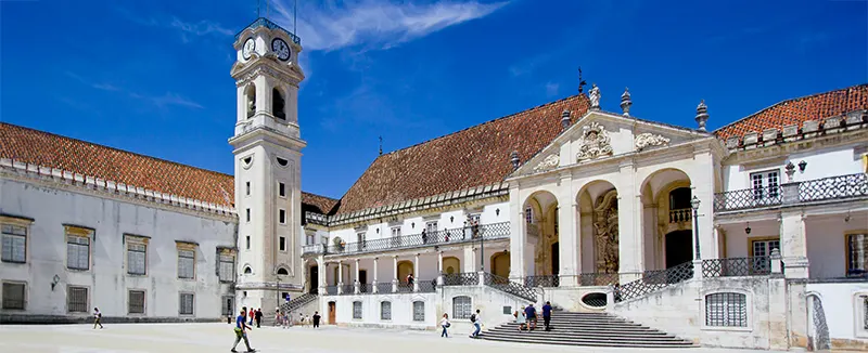 Historisch gebouw met klokkentoren op de voorgrond, prominent aanwezig in Coimbra