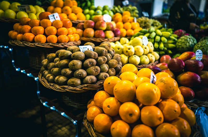 Colorful assortment of fresh fruits displayed in woven baskets, showcasing a variety  of textures and colors. 