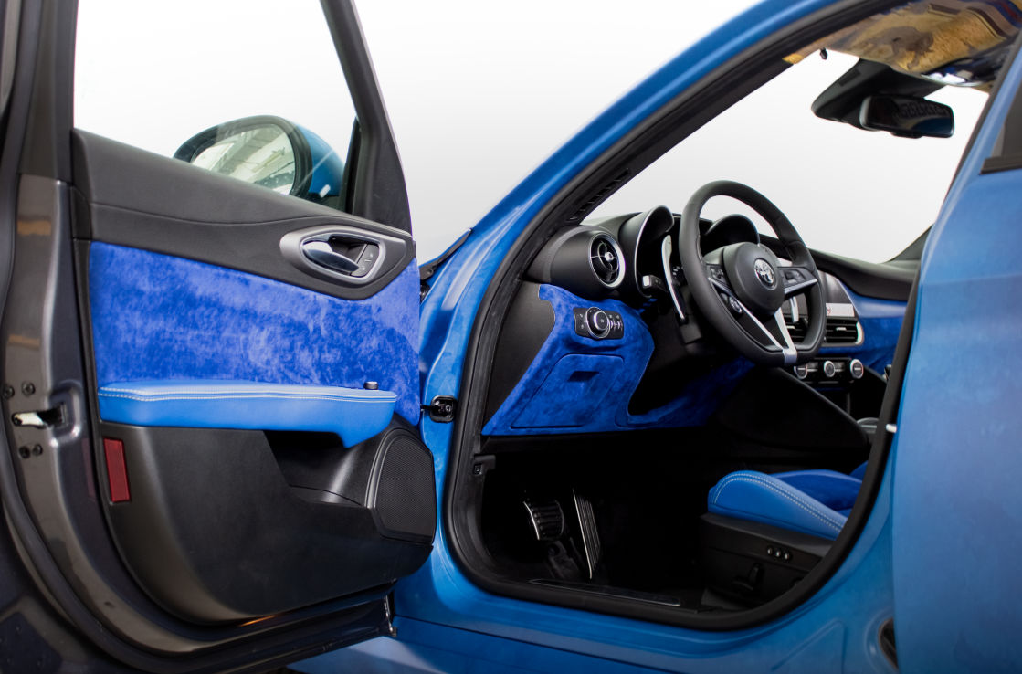 Interior shot of a blue Alfa Romeo Giulia, looking in through an open door