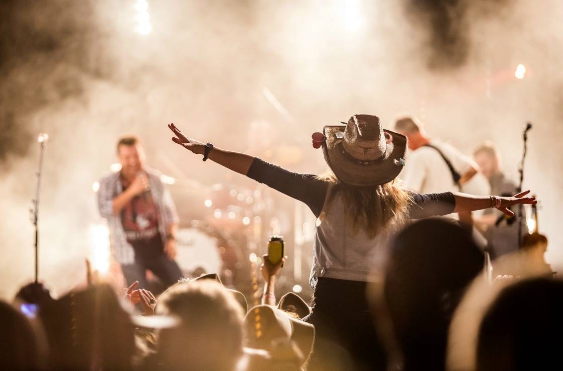 Frau mit Cowboyhut beim Country-Konzert.